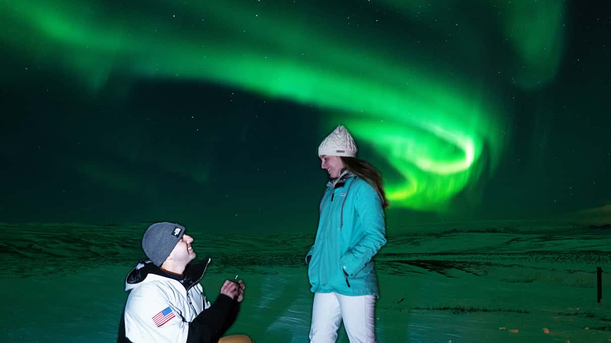 Viajera fotografiando la aurora boreal con un trípode en Islandia