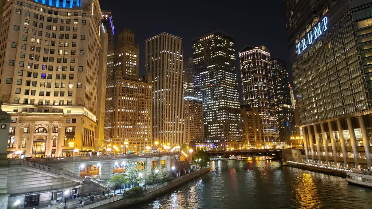 The Chicago River at night with lit buildings and their reflections on the water