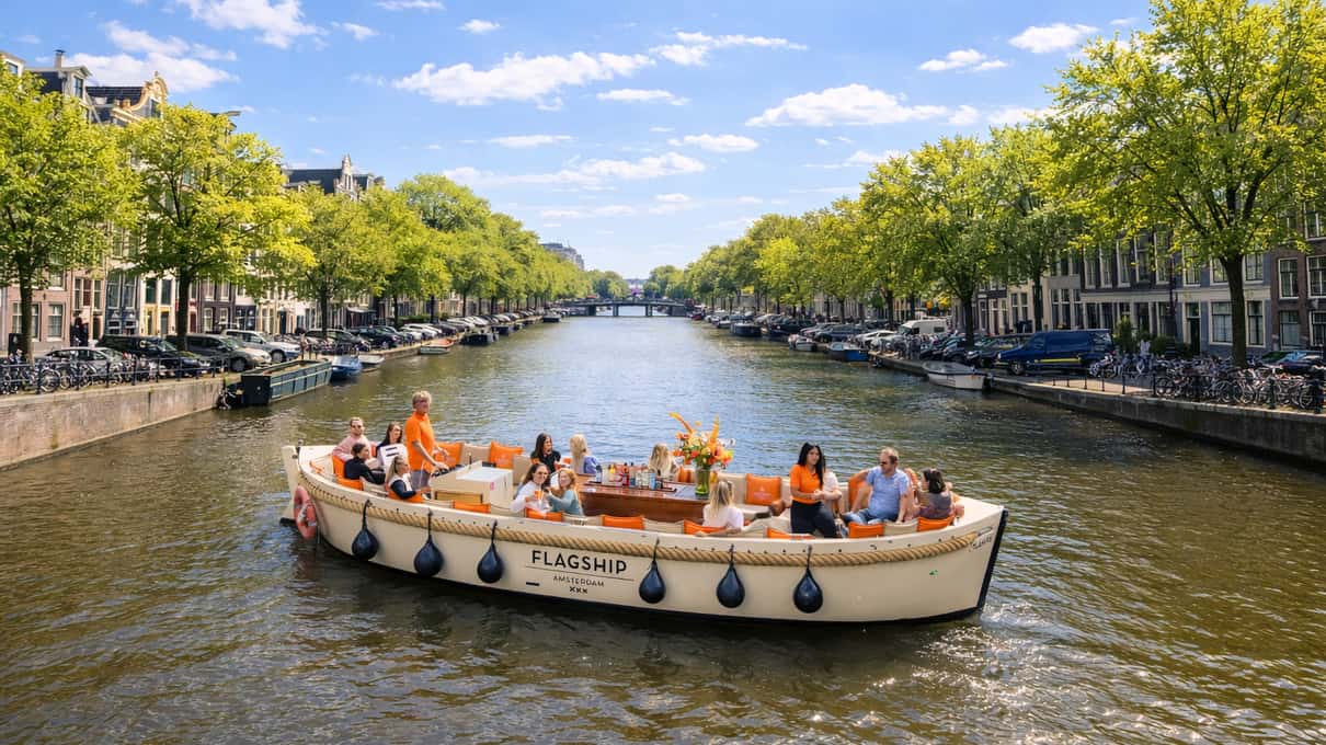 Offenes Boot mit Gästen auf einer breiten, von Bäumen gesäumten Gracht an einem sonnigen Tag