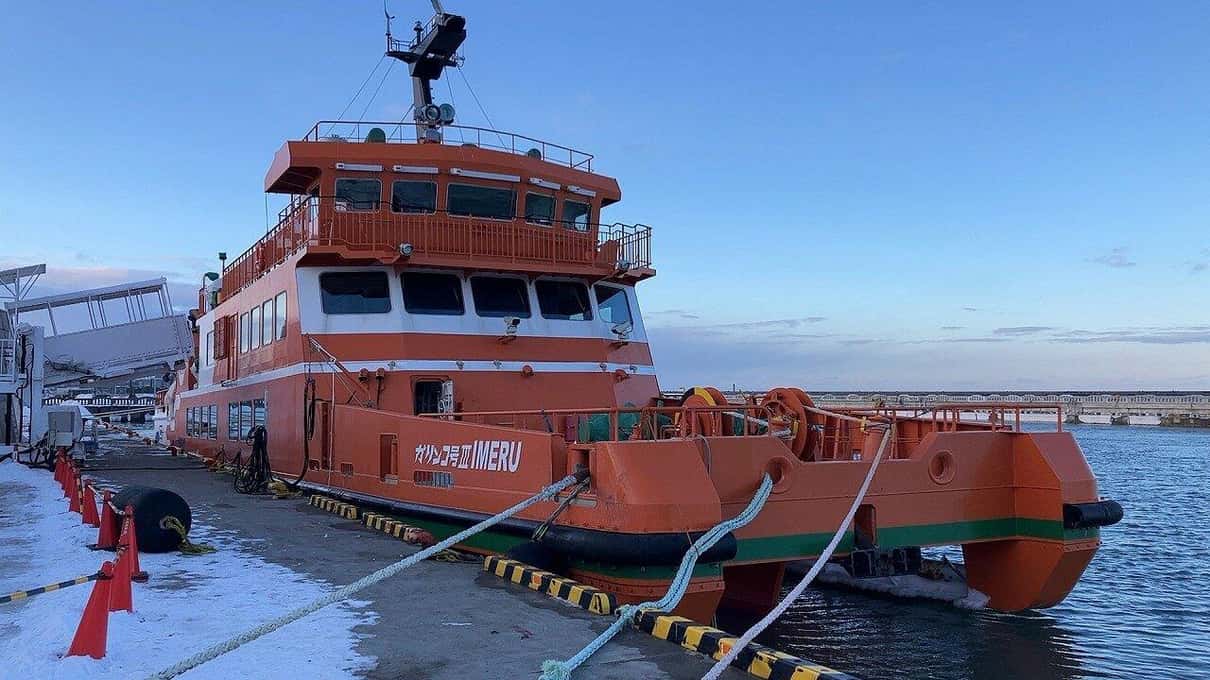 The red Garinko III icebreaker moored at the quay in Monbetsu under a clear blue sky