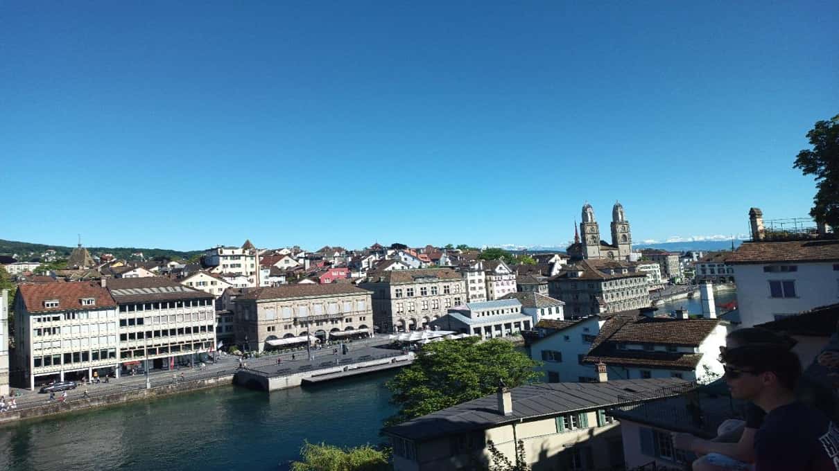 The twin towers of the Grossmünster rising above the rooftops of Zurich's Old Town under a clear blue sky