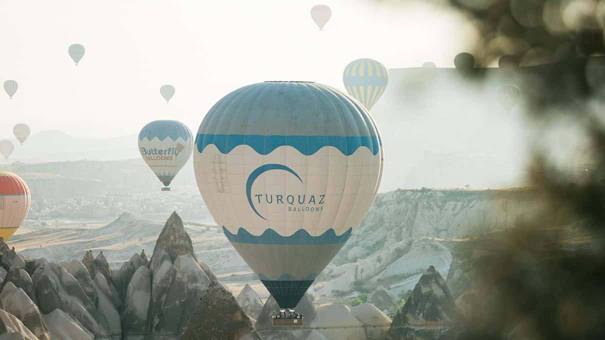 Globo aerostático sobre los valles de Göreme con más globos al fondo