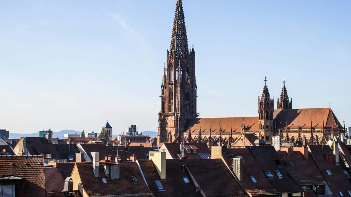 The red sandstone Freiburg Minster rising above the tiled roofs of Freiburg's old town
