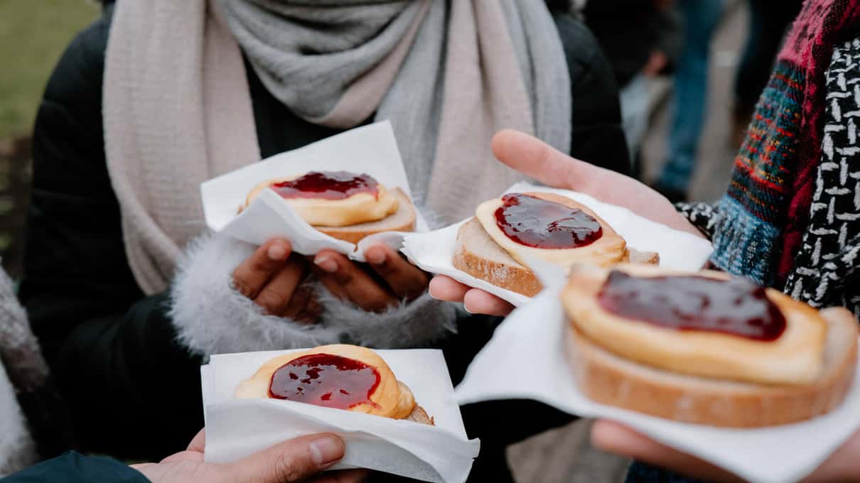 Hands holding homemade Czech Christmas cookies and small pastries on a Prague market walk