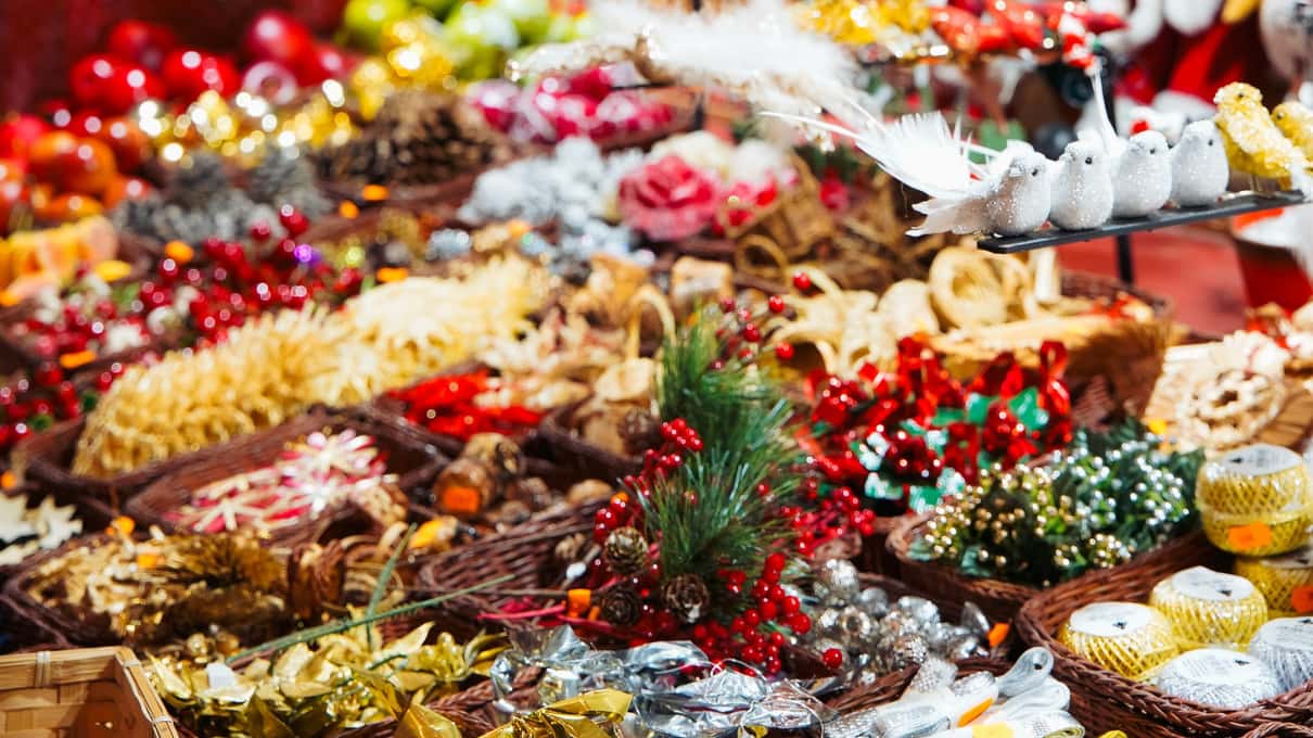 A wooden Christmas market chalet piled high with bags of sweets, colorful candies and hanging decorations