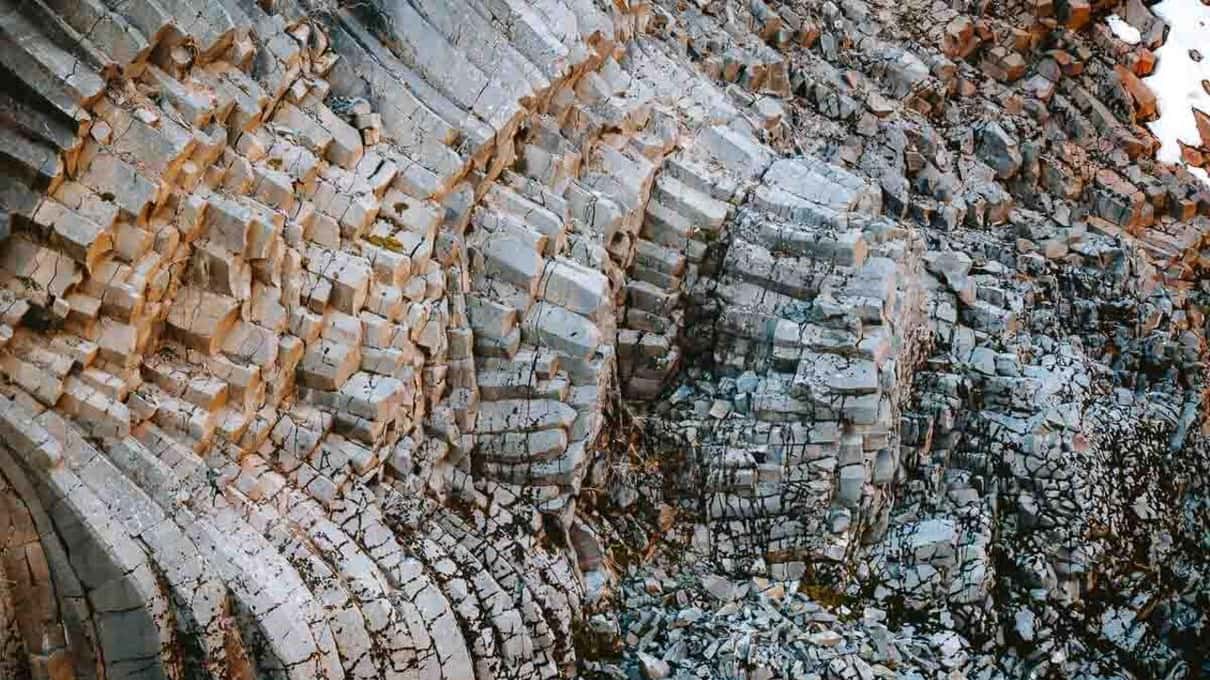 Close view of curved and fanned basalt columns in the wall of Stuðlagil canyon