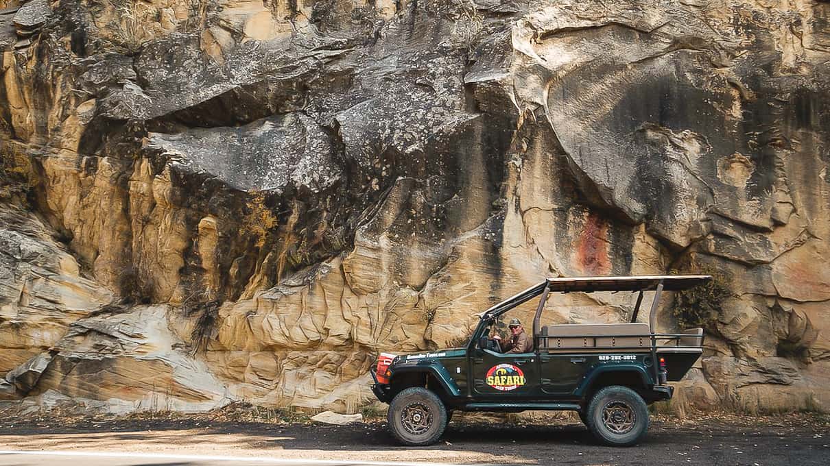 A jeep on the sealed switchback road through Oak Creek Canyon with tall canyon walls above