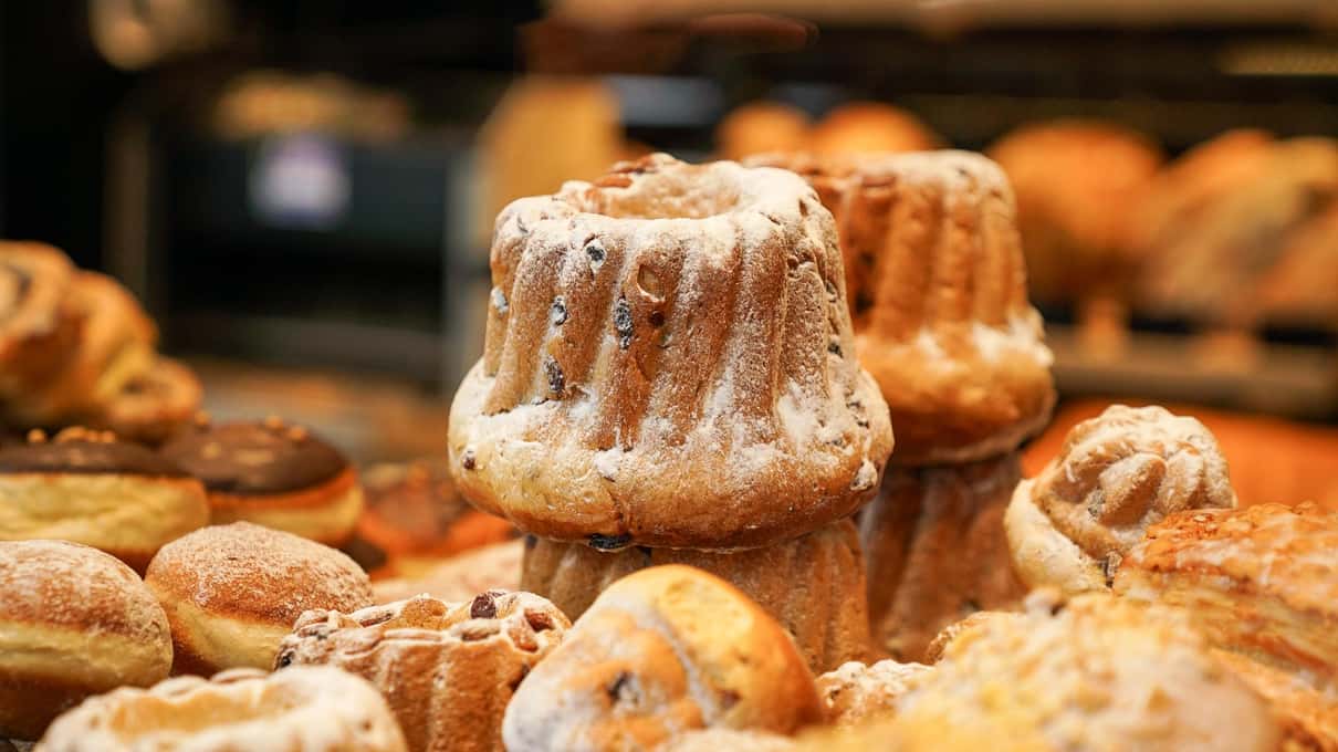 Golden kugelhopf cakes with their fluted ring shape stacked on a bakery counter