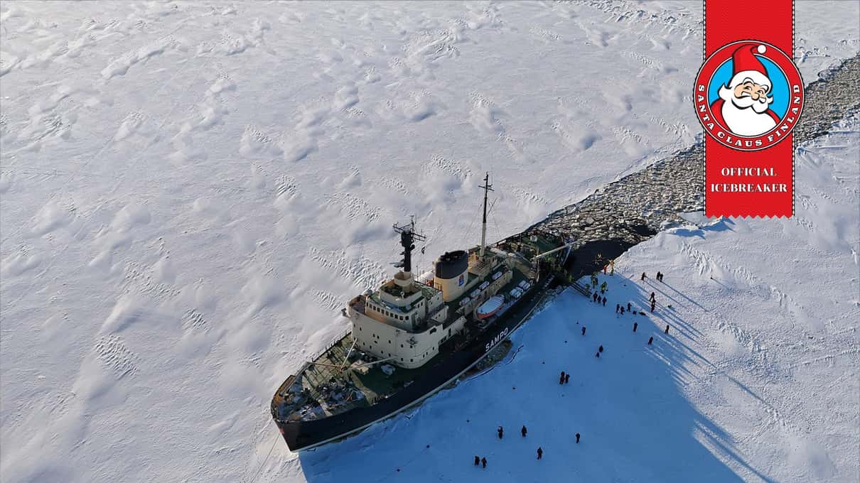 Aerial view of the icebreaker Sampo cutting a dark channel through snow-covered sea ice