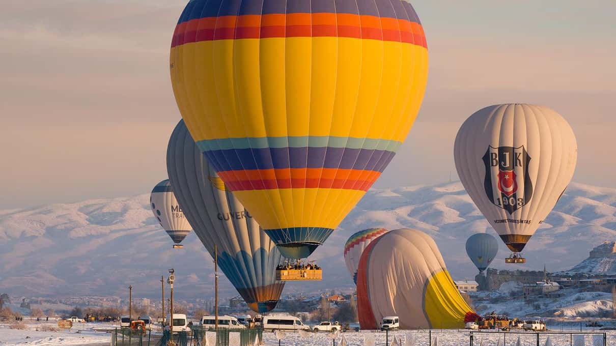 Balon Urgup Balloons nad skalnymi formacjami Kapadocji wczesnym rankiem