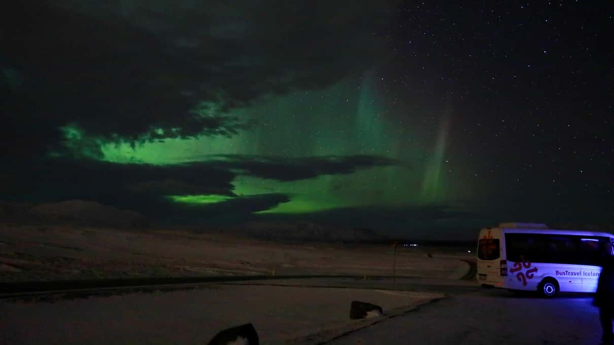 Aurore boréale verte au-dessus d'un paysage islandais enneigé