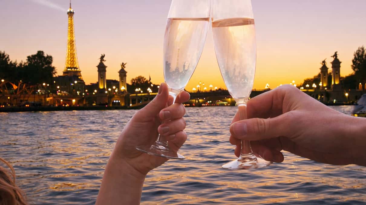 Copa de champán a bordo de un crucero por el Sena al atardecer