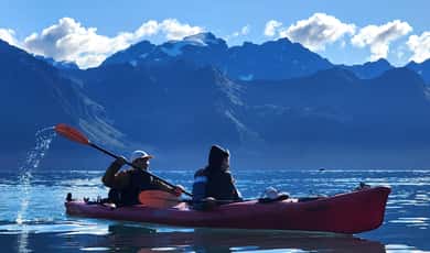 Seekajak auf dem Wasser vor einer Bergkulisse