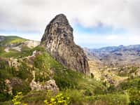 Roque de Agando rock above green La Gomera hills
