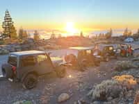 Jeeps at sunset above clouds