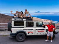 White safari jeep with guests, red-shirt guide