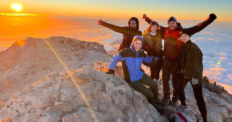 Group on summit at sunrise