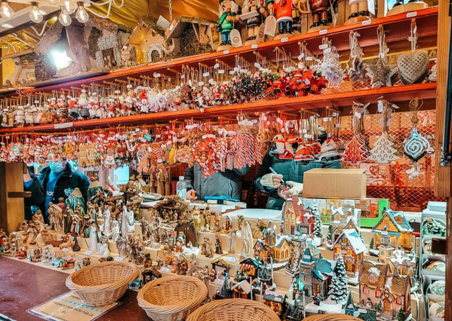 Place des Dominicains, mercado de Navidad de Colmar — figuras de belén en un puesto de decoración