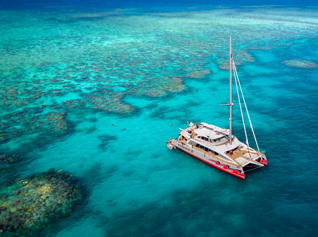The red sailing catamaran over the outer reef