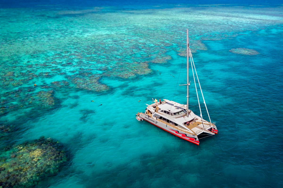 The red sailing catamaran over the outer reef