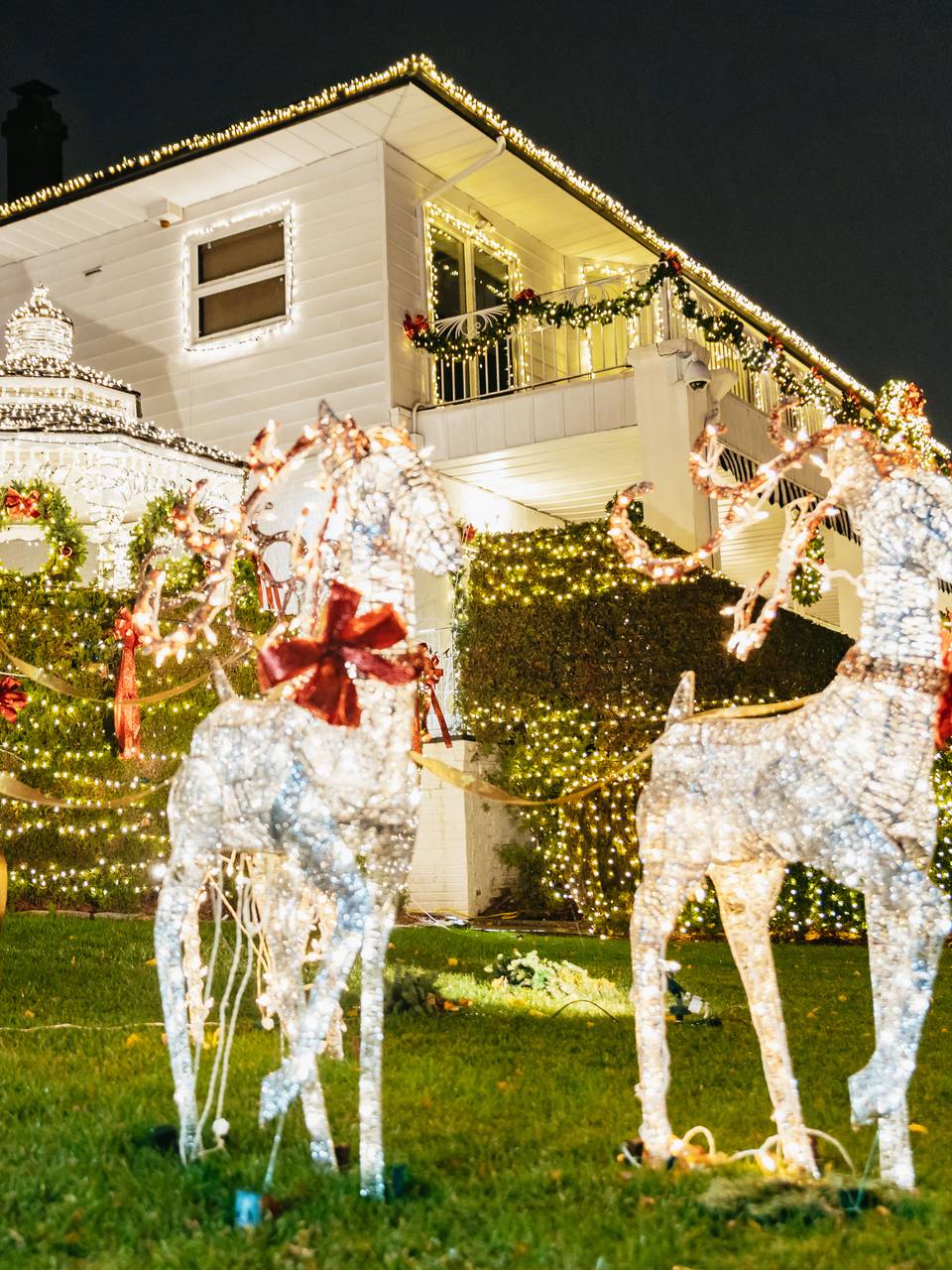 Santa and white light-up reindeer on a lawn