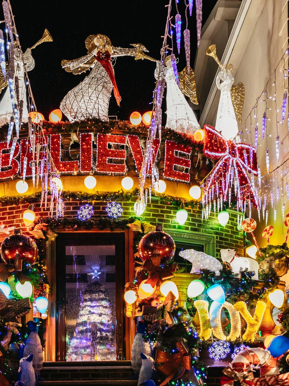 House with a 'Believe' sign, angels and heavy garlands