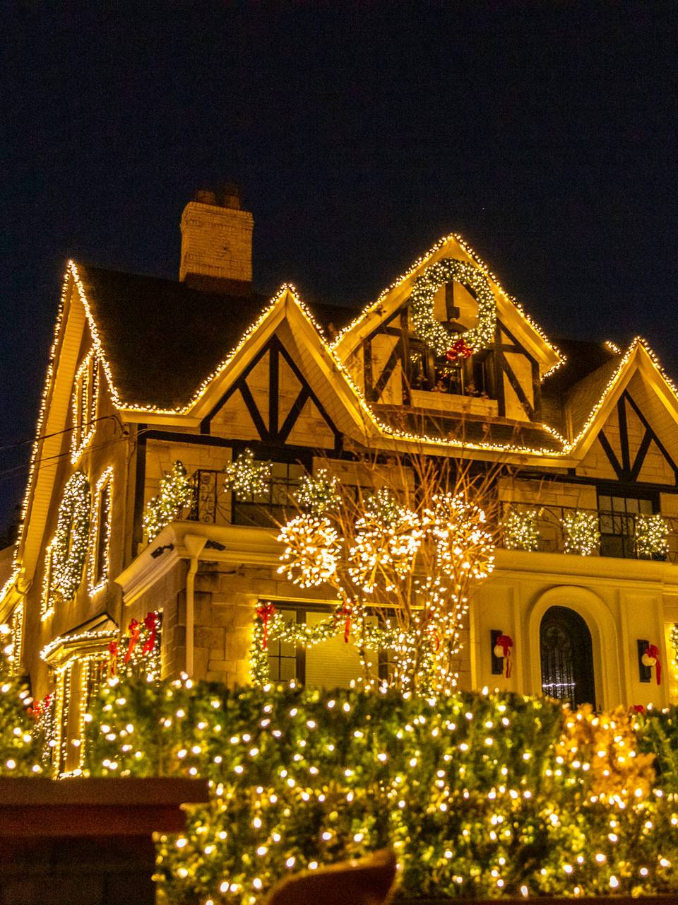 Tudor-style house outlined in warm white lights
