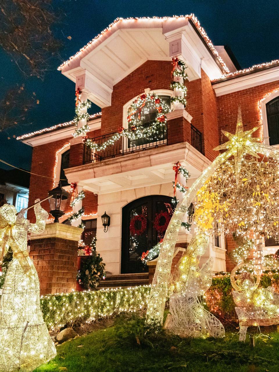 Brick house with white-light angel figures on the lawn