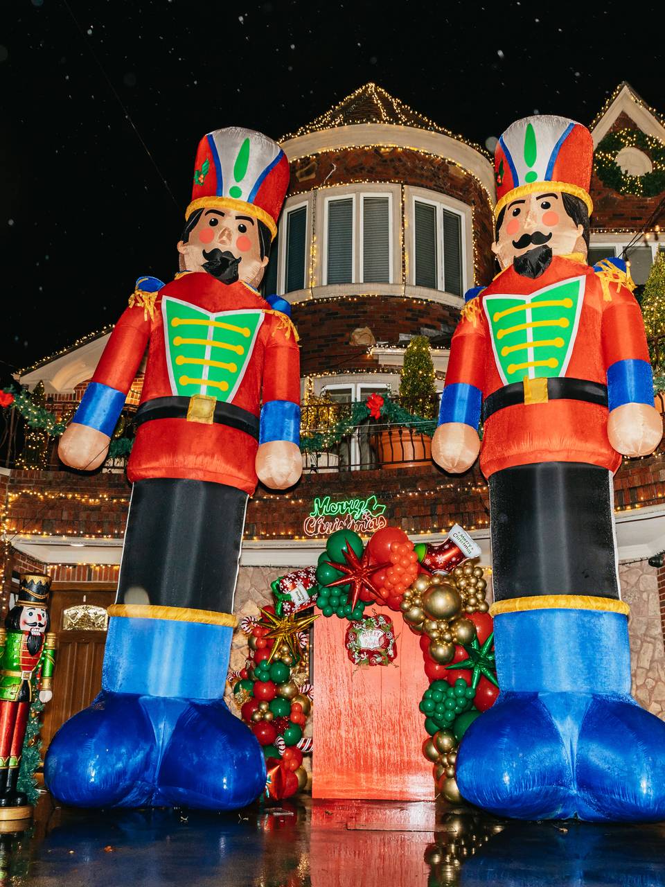 Two giant nutcracker figures in front of a house