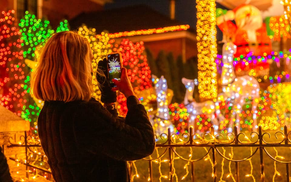 Visitor photographing a lit reindeer display