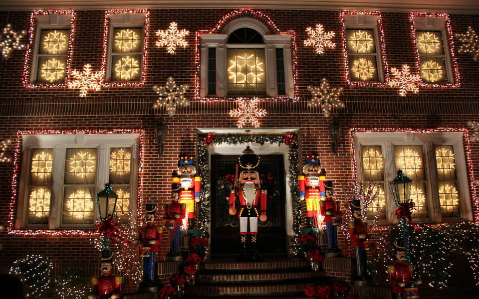 Brick house facade with nutcrackers and lit snowflakes