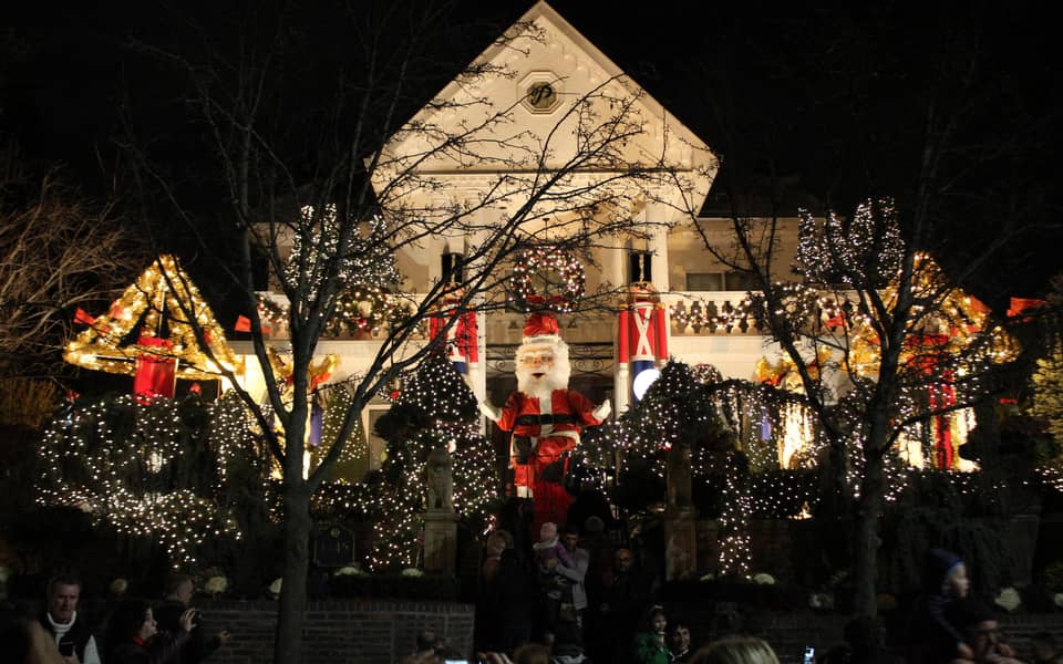 Large white house with a Santa figure, lit at night