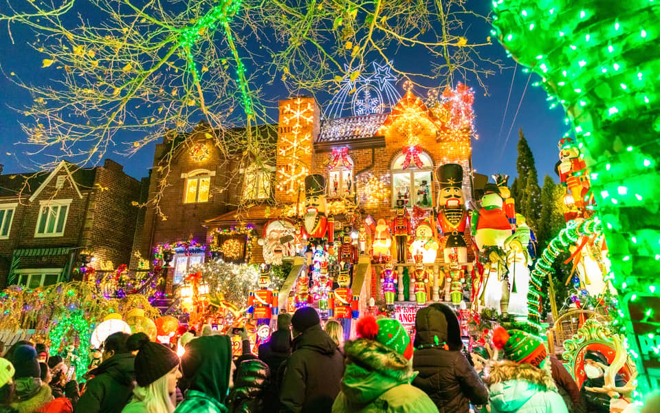 Heavily decorated house with nutcrackers and a crowd on the street at night
