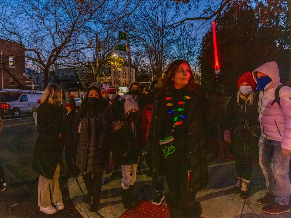 Guide with a group on the sidewalk at dusk