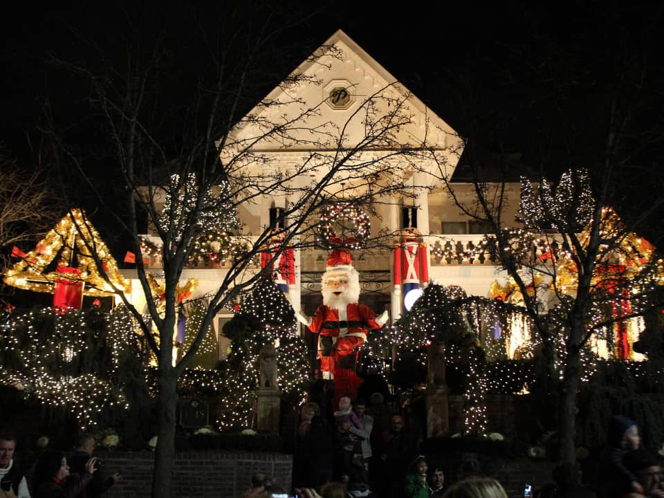 Large white house with a Santa figure, lit at night