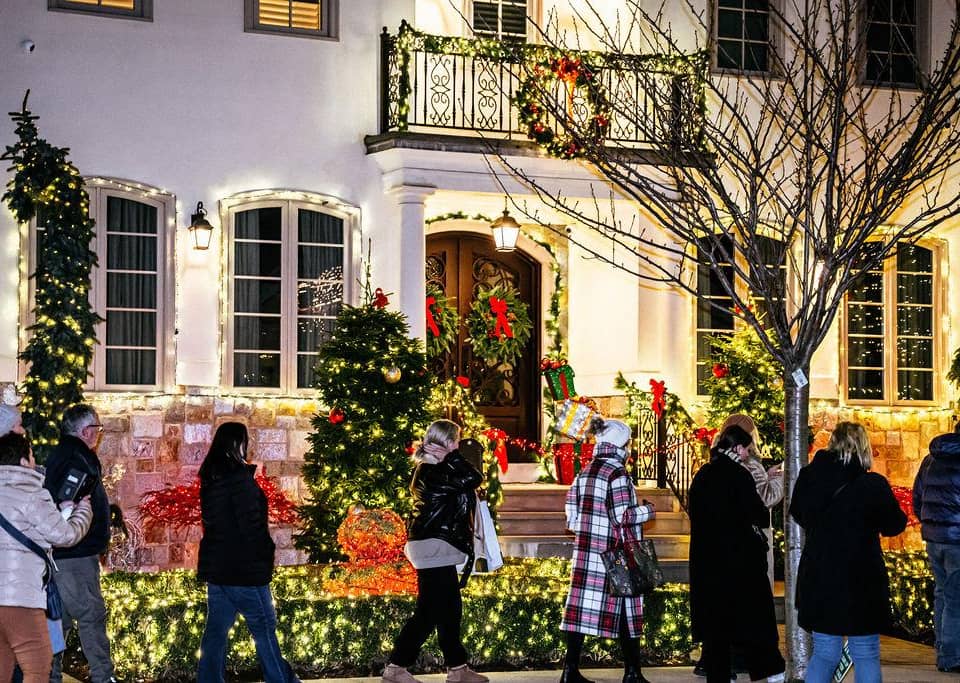 White house with wreaths and visitors on the sidewalk