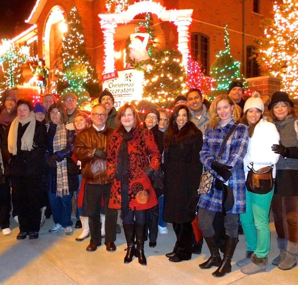 Tour group posing in front of a lit house