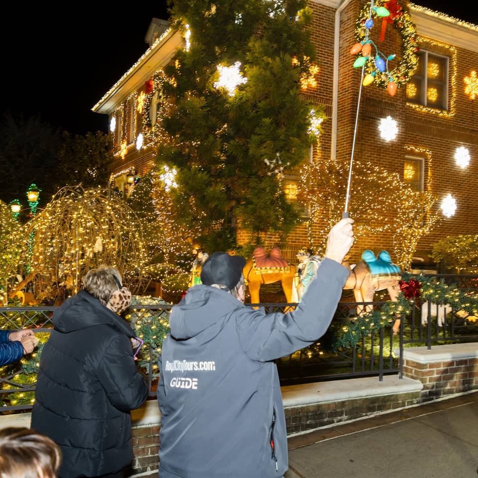 Guide pointing out a house to a group on the sidewalk
