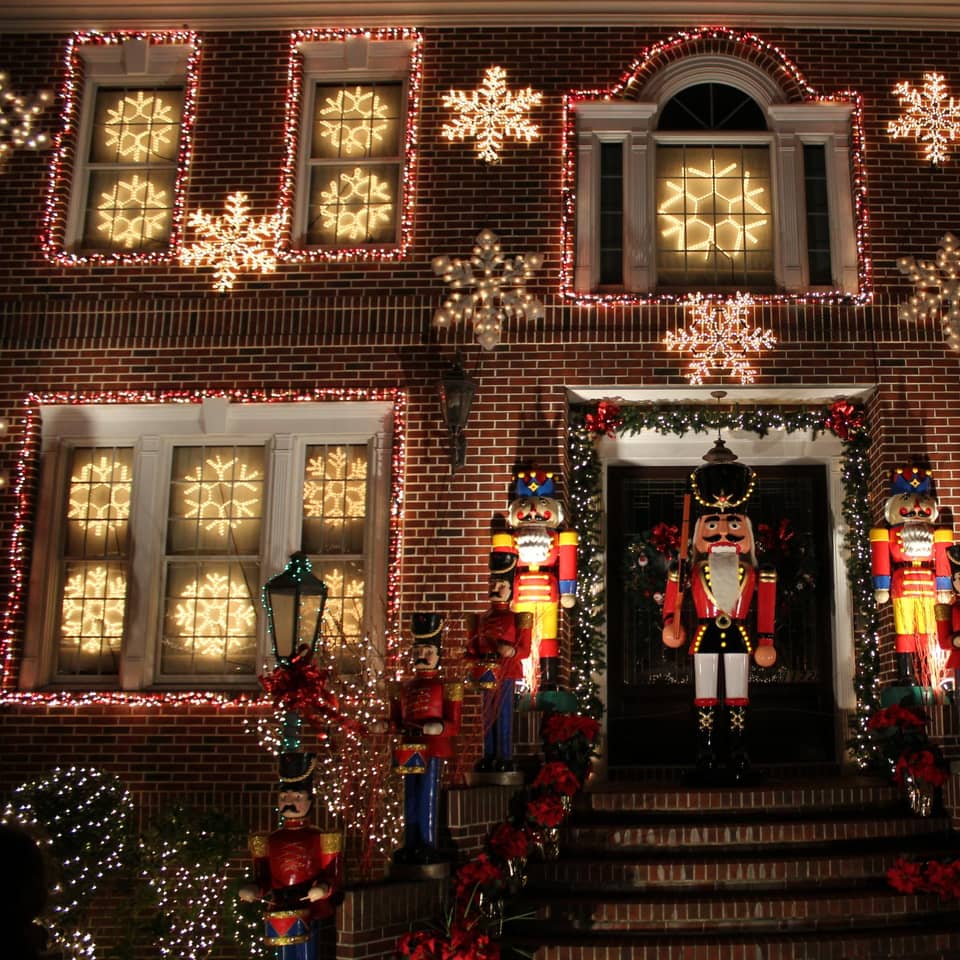 Brick house facade with nutcrackers and lit snowflakes