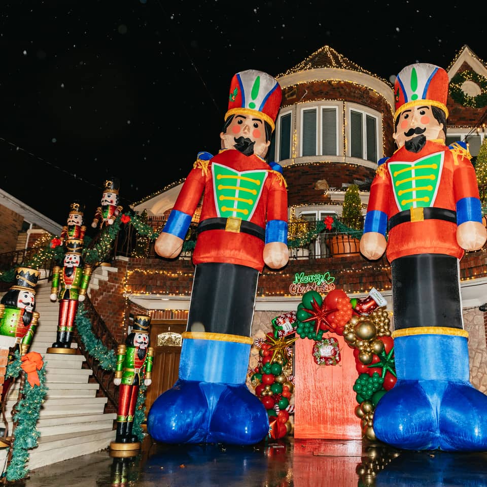 Two giant nutcracker figures in front of a house