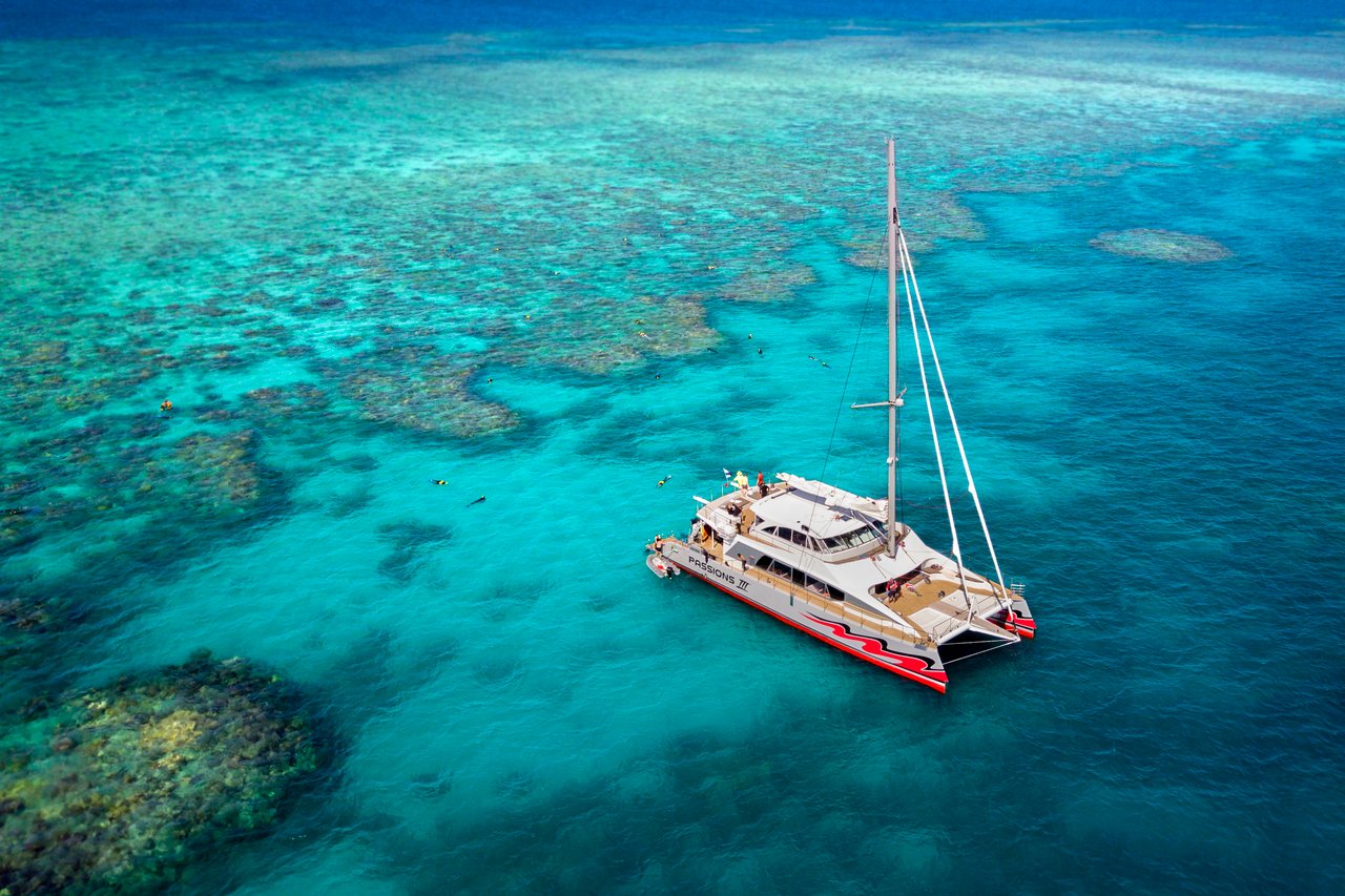 The red sailing catamaran over the outer reef