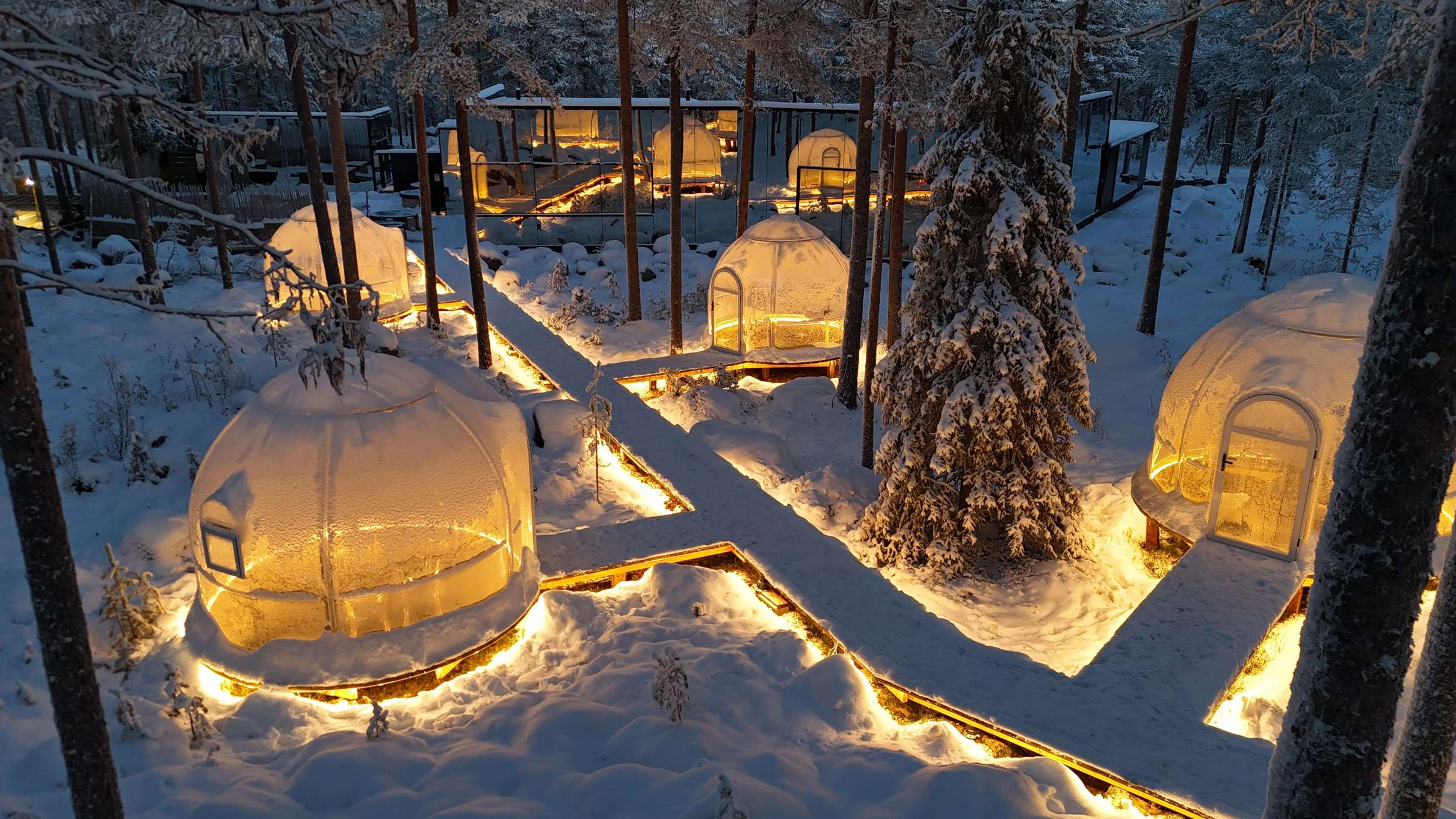 Diner prive dans un igloo de verre eclaire au milieu de la foret arctique pres de Rovaniemi