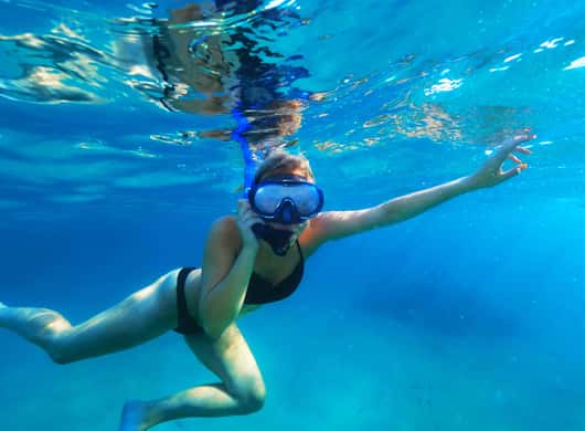 Snorkelen in baai bij Ibiza met rotsen en zeegras