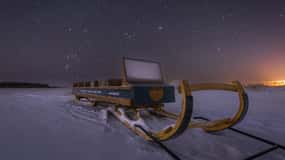 Ii: Snowmobile sleigh trip on frozen sea under starlit sky