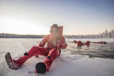 Flutuação no gelo durante o dia em Rovaniemi, experiência no lago gelado