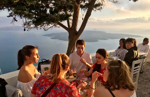 imagem n.1 de Santorini: Excursão a pé ao pôr do sol com comidas e bebidas locais atividade em Cíclades, carregada pelo fornecedor
