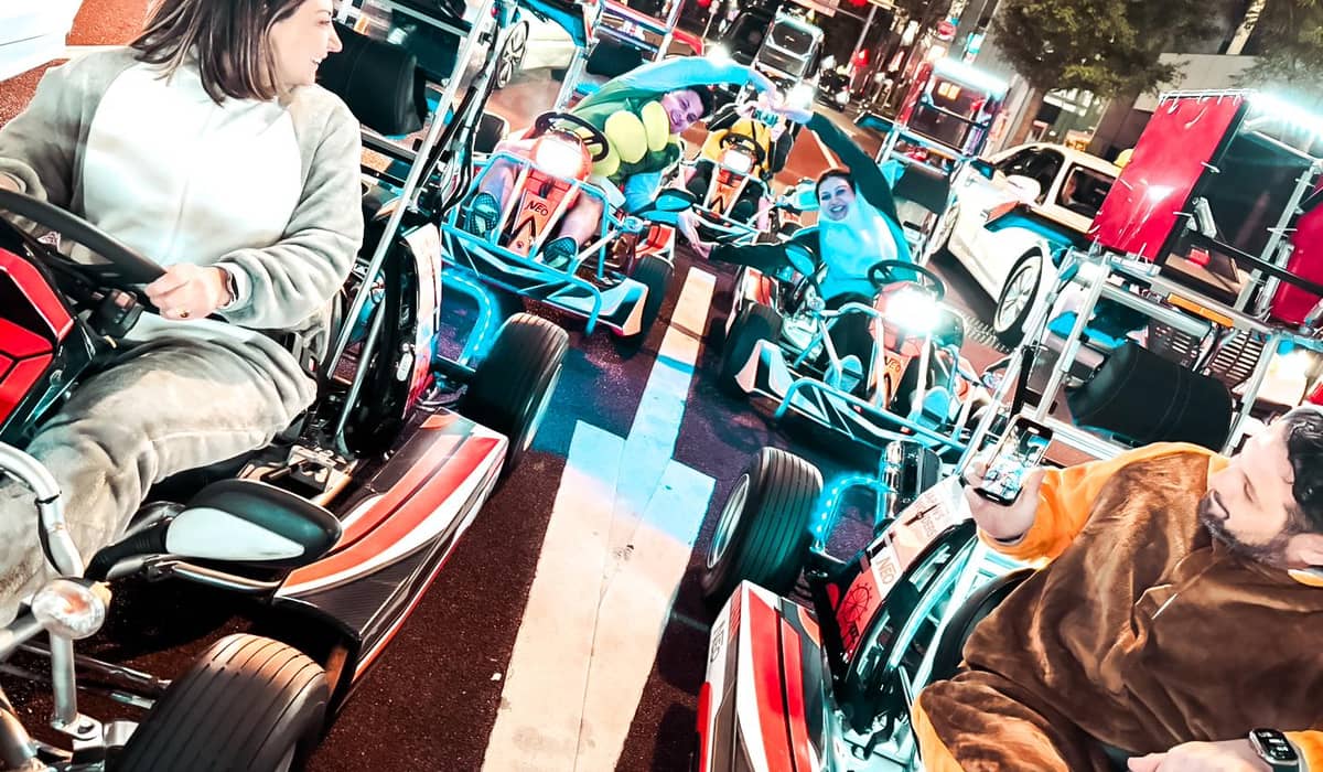 A woman driving a teal kart on a Ginza street. Photo from the operator's GetYourGuide listing.
