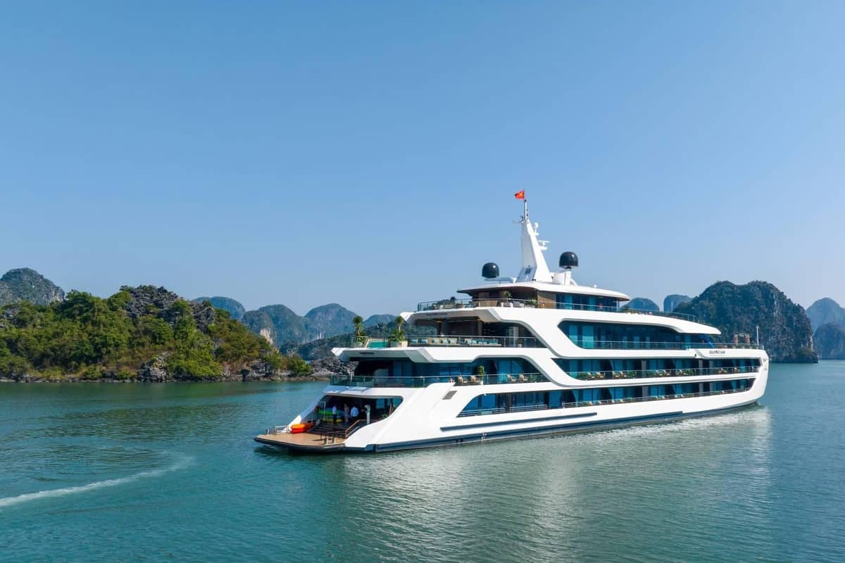 Ein weißes Kreuzfahrtschiff mit fünf Decks zwischen den Inseln