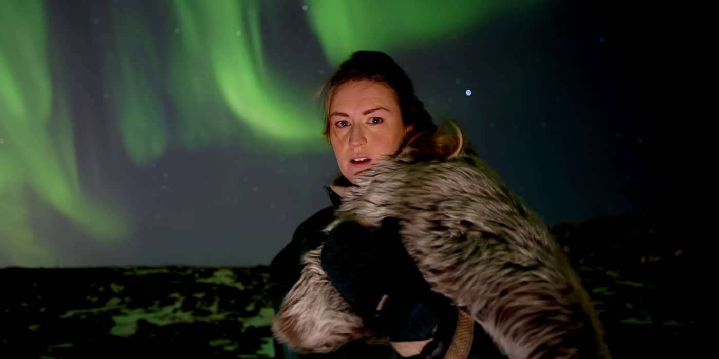 Woman holding a fur cloak, Viking-costume portrait under aurora