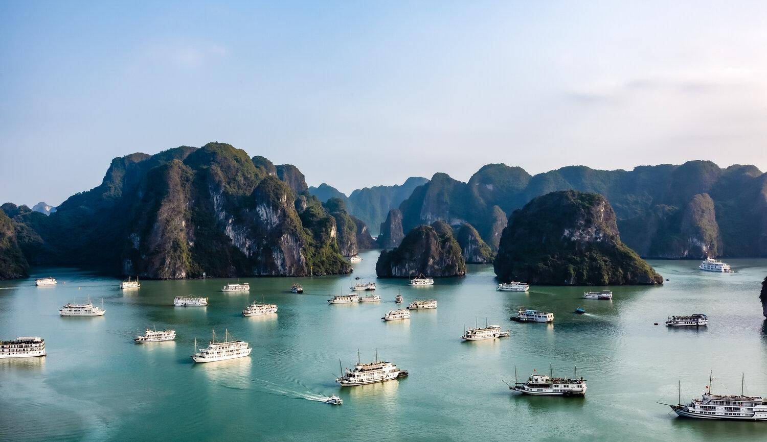 A small cruise boat among limestone islands in Ha Long Bay